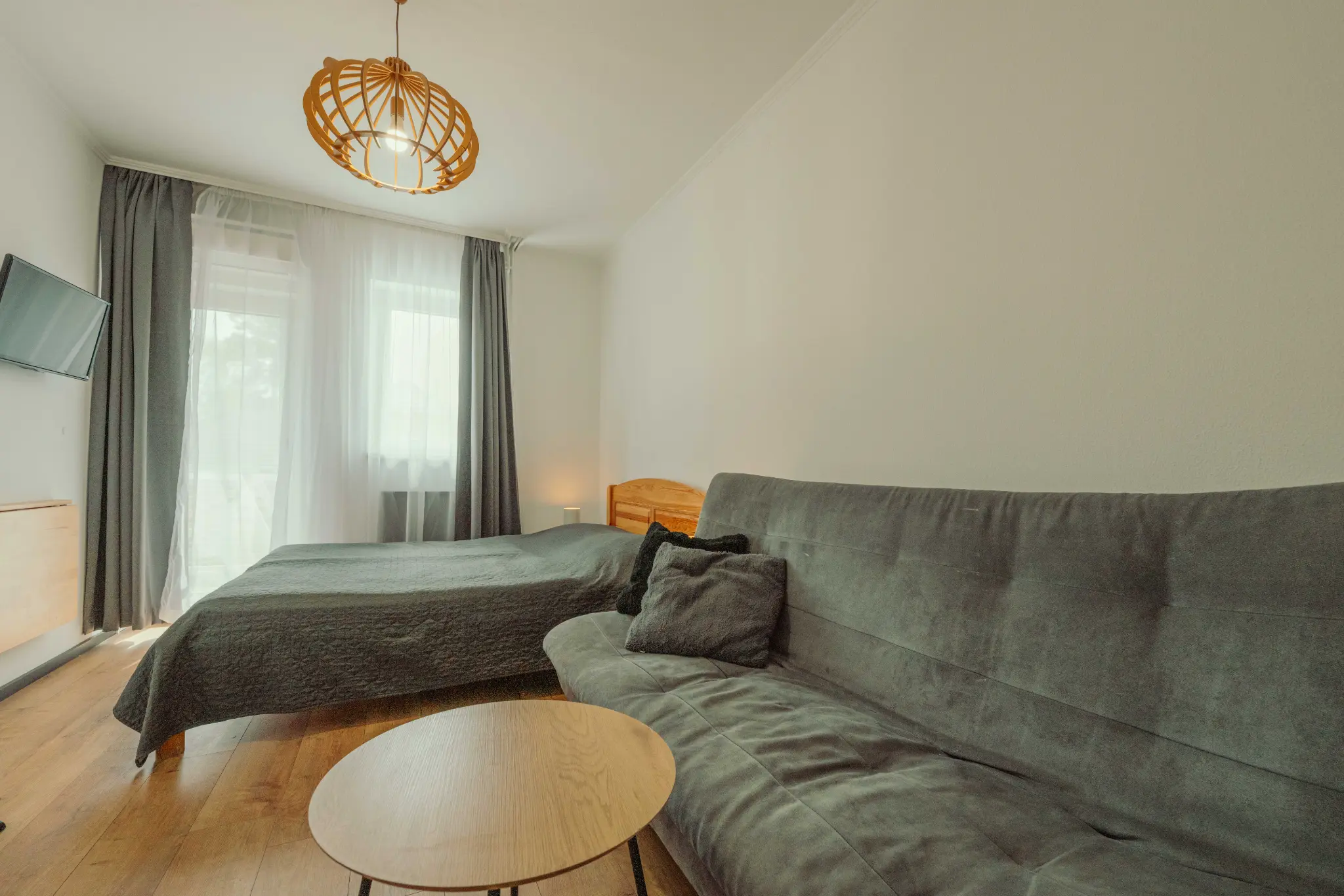 Caesar Vendégház kétfős apartman Siófok – hálószoba franciaággyal, fa mennyezeti lámpa, Balaton közelében
